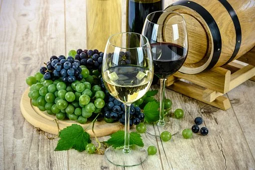 Bicchieri Di Vino, uno rosso e uno bianco con accanto dei grappoli d'uva