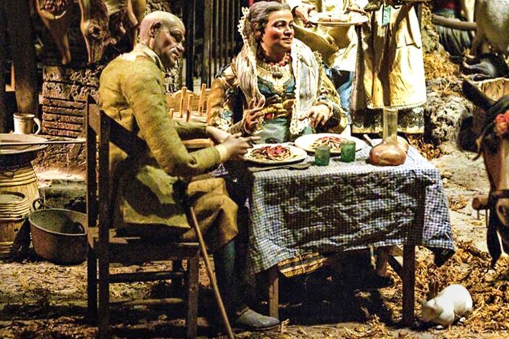 Spaghetti -Image of a man and a woman sitting at the table ready to eat a large plate of spaghetti with tomato sauce