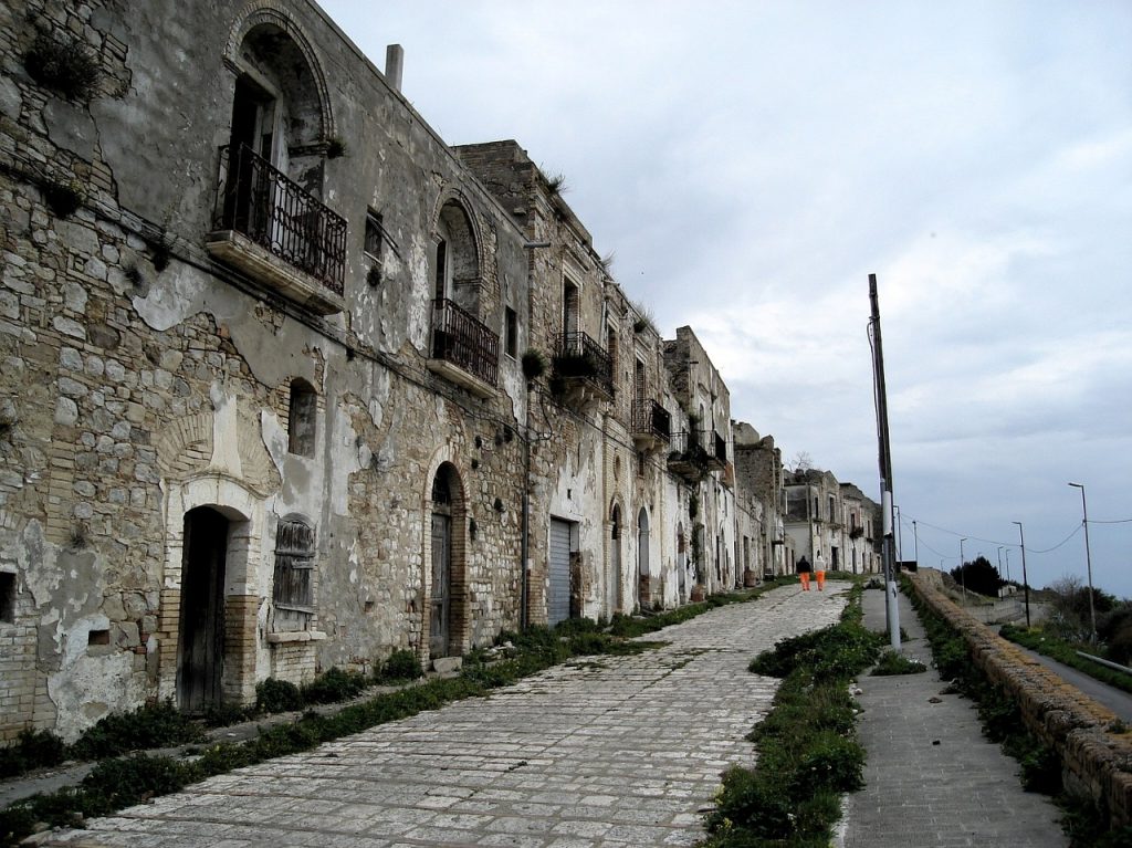 Craco. Imagen de una antigua calle pavimentada bordeada de edificios históricos en el pueblo de Craco