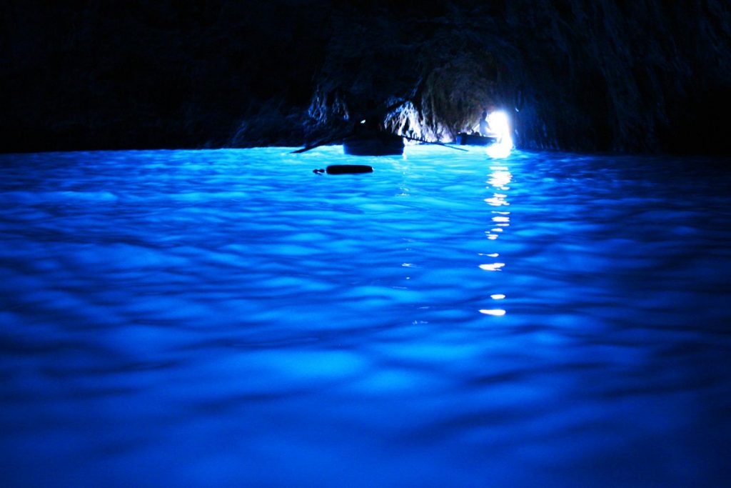 Capri. Grotta Azzurra di cui spicca il mare di un blu intenso illuminato dalla luce proveniente dalla piccola apertura di fondo della grotta oscura