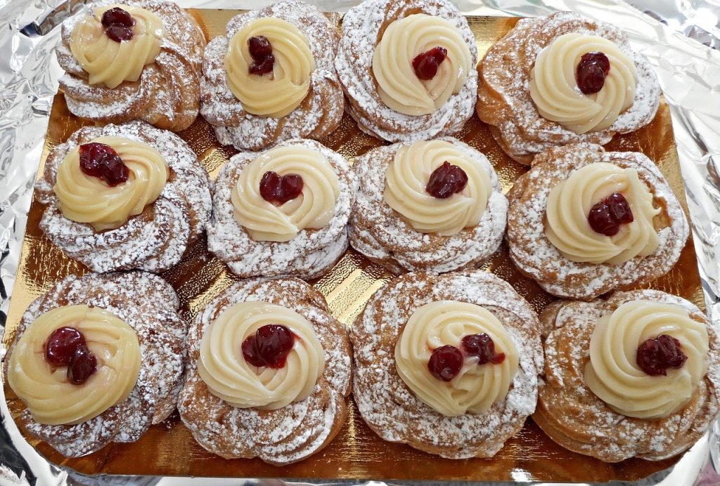 Papa - Bild eines Tabletts voller Zeppole, frittiertem Gebäck mit Sahne und Schwarzkirsche