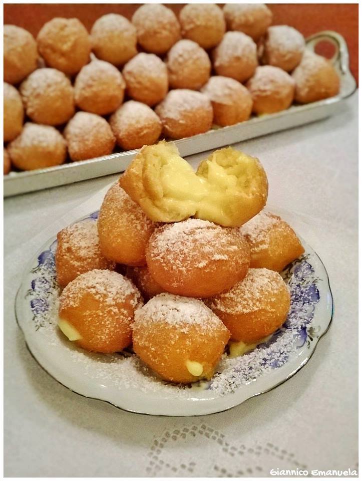 Castagnole with cream and icing sugar placed on a plate