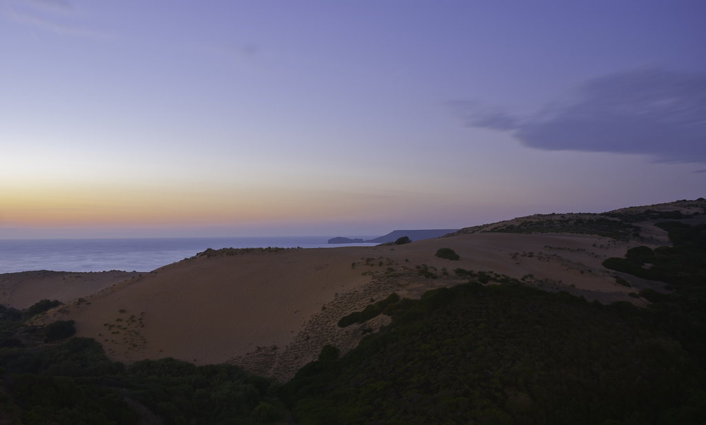 Torre dei Corsari. Desert at sunset with sand dunes under the sky with shades of purple, yellow and orange
