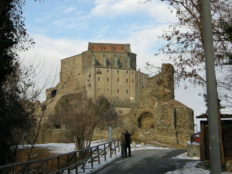 sacra di san michele all'orizzonte con la neve ai lati della strada