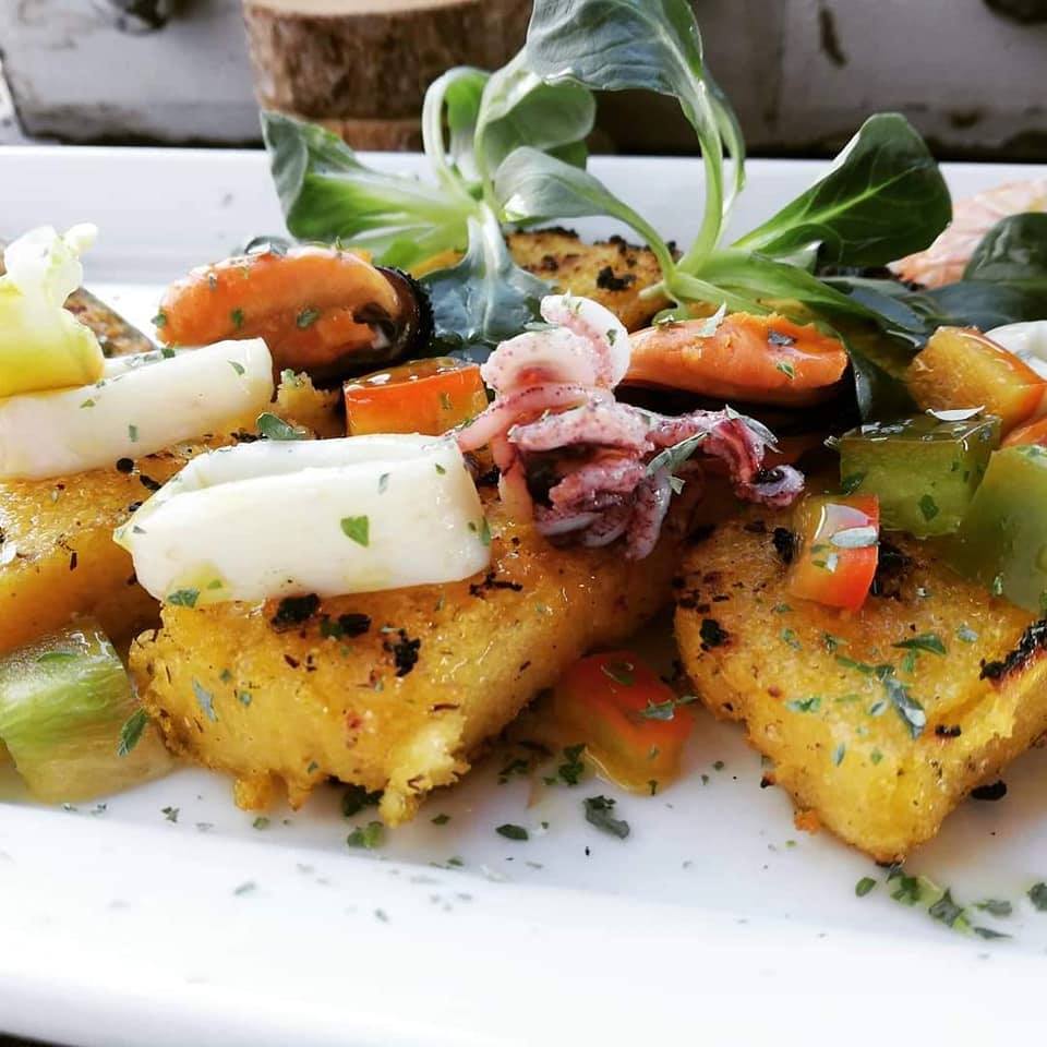 Polenta croutons with 5 cereals with squid and mussels decorated with parsley