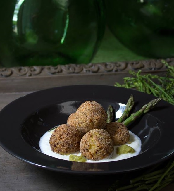 piatto nero con gli Arancini di riso agli asparagi con mousse di mozzarella