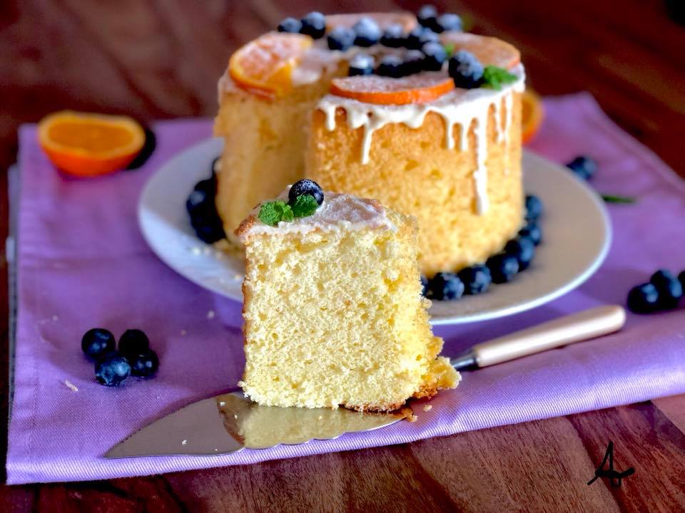 closeup of a slice of chiffon cake with orange, white chocolate and blueberries