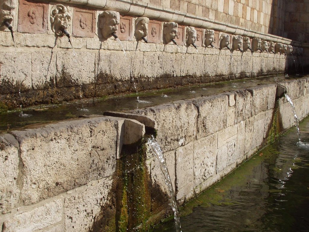 Fountain of the 99 spouts. image of the fountain with masks and stone cladding