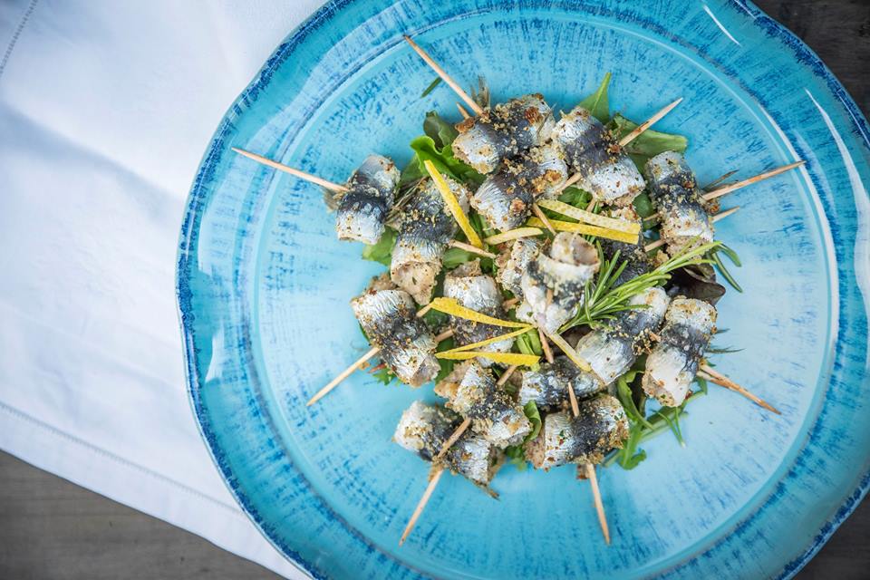 blue plate with gratinated sardines with rosemary