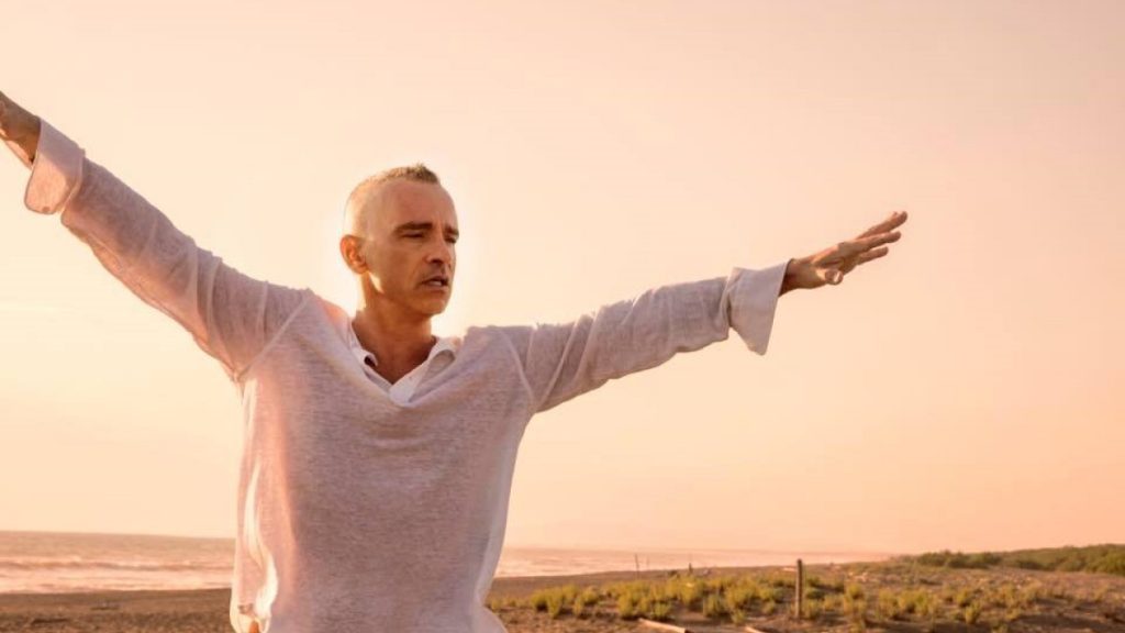 Eros Ramazzotti in a white T-shirt with open arms