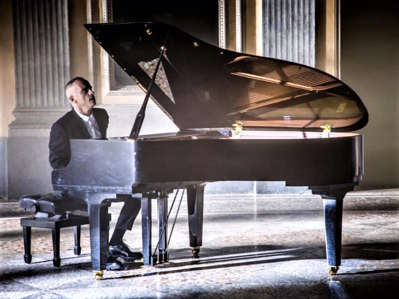 Eros Ramazzotti canta seduto al pianoforte