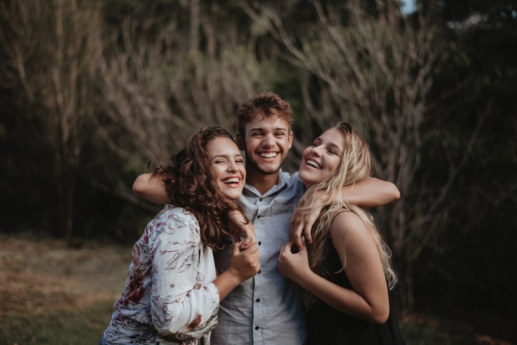friendship between man and woman - three friends hugging each other