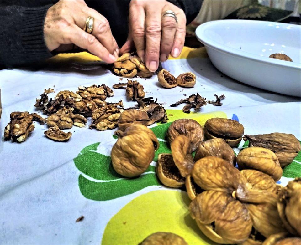 Conflict forever - close up of hands filling figs with nuts