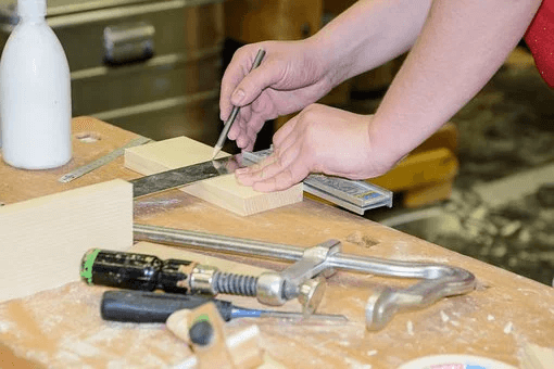 5 cose da fare in quarantena - mani che prendono le misure con un righello per tagliare un pezzo di legno