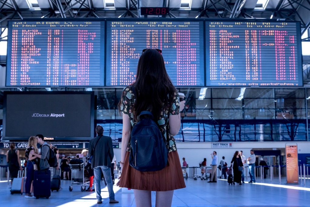 Giada - ragazza di spalle che guarda il tabellone degli orari in aereoporto