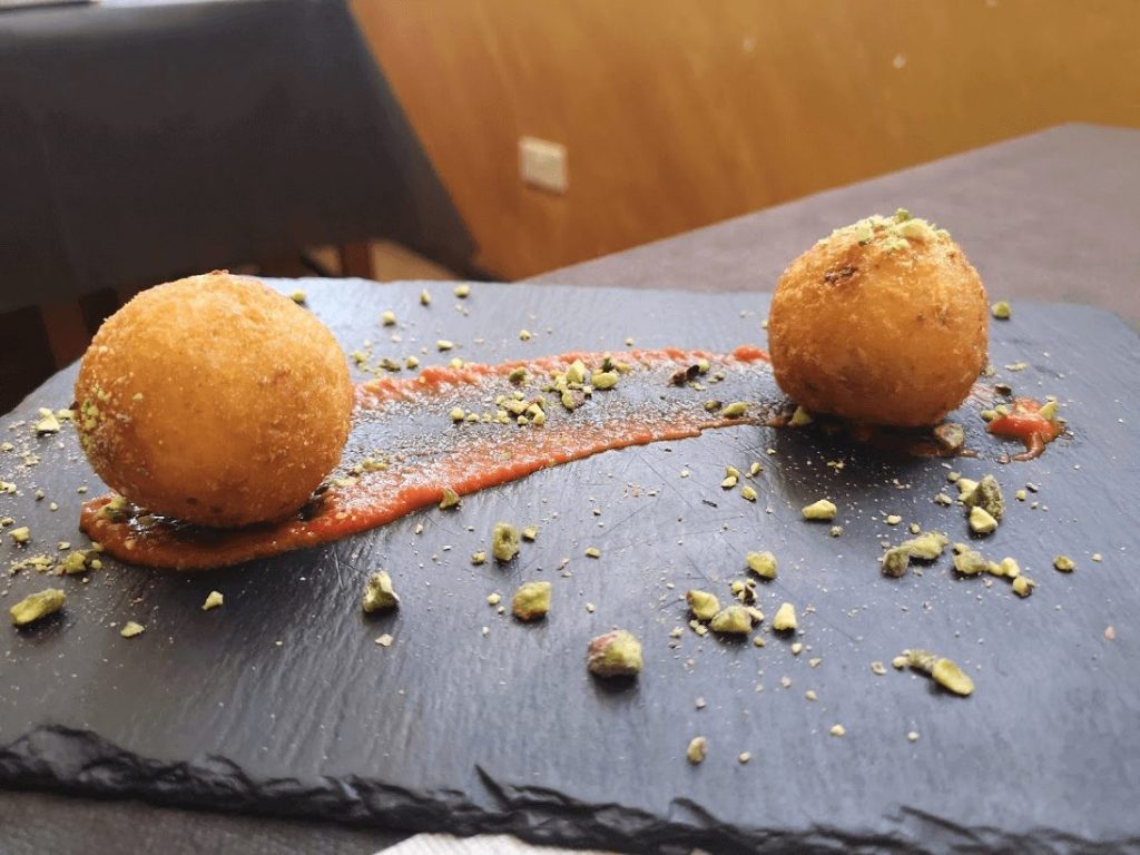 Arancini - due arancini su un piatto nero