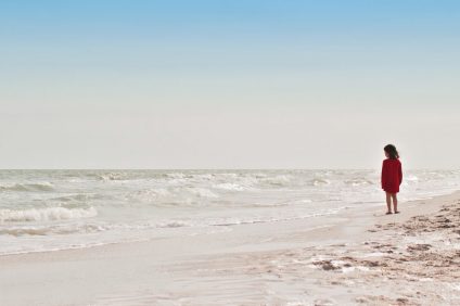 libri - una bambina vestita di rosso in spiaggia