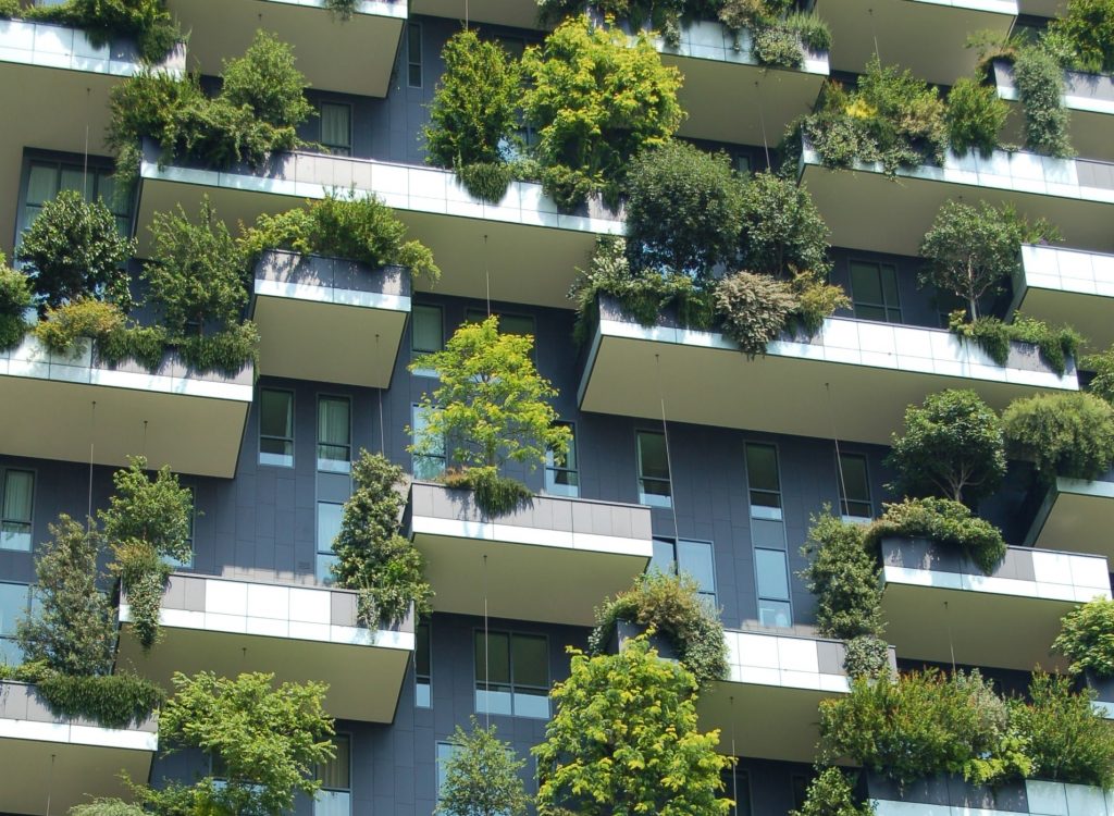 casas - Una mansión con varios balcones con plantas