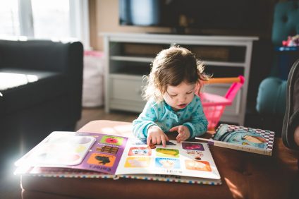 companies - a child looking at a colorful book