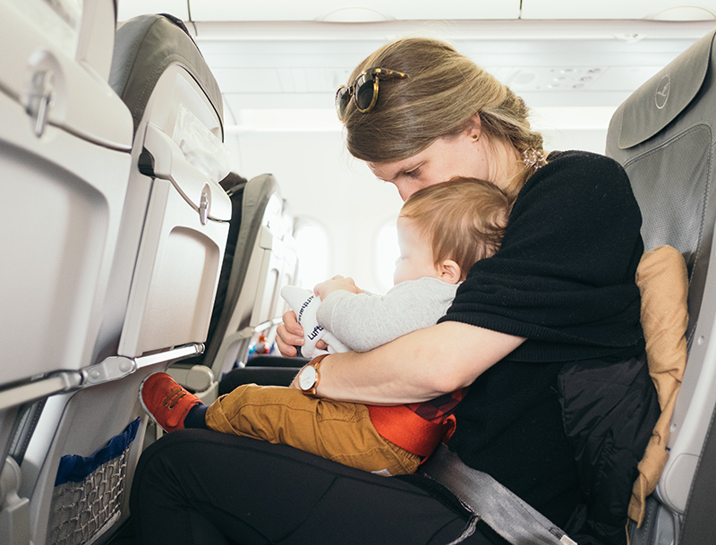 mother's - a mom with son sitting inside the plane