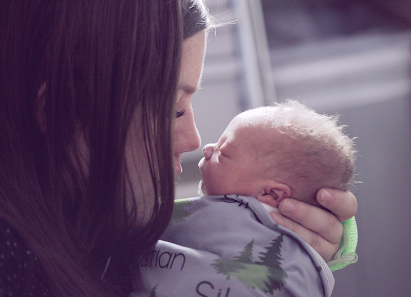 moms - a mom holding a newborn baby in her arms