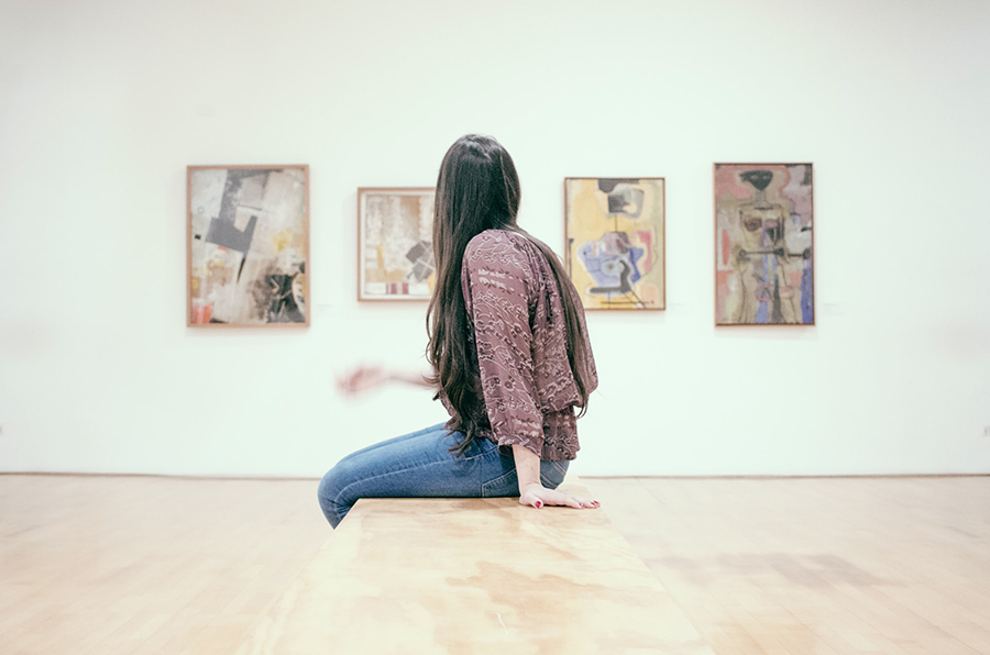 Arte - ragazza seduta che guarda i quadri