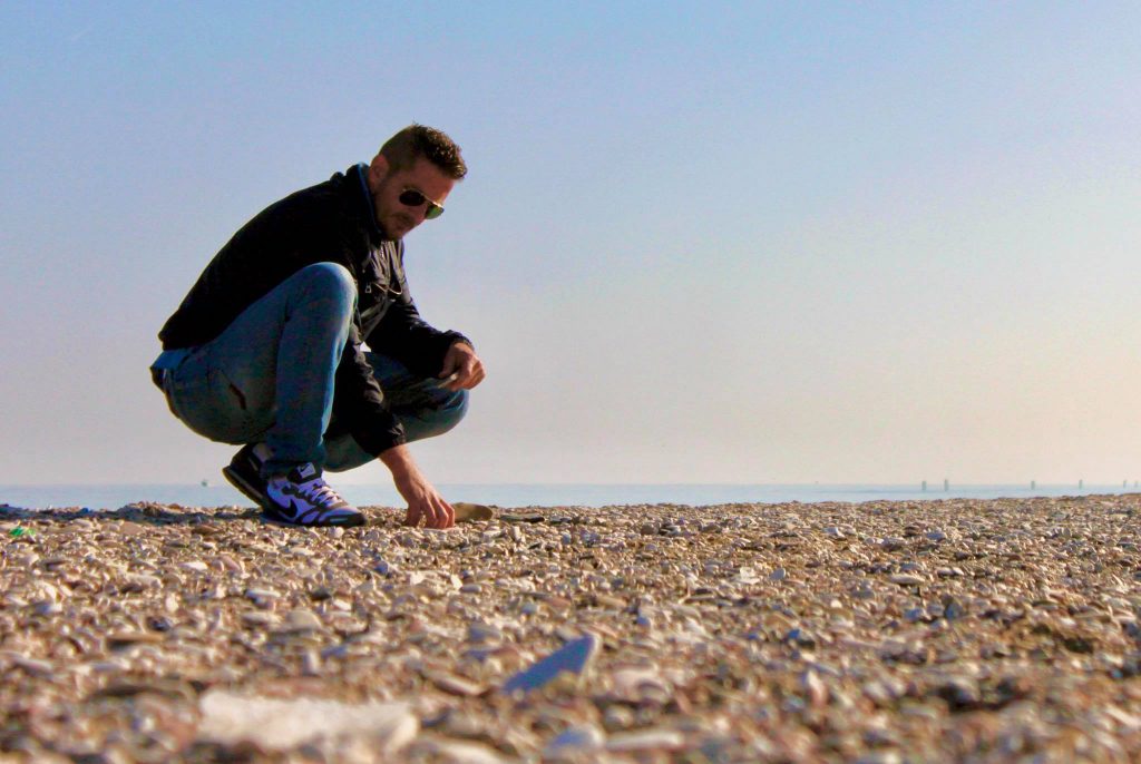 Stefano raccoglie i sassi sulla spiaggia