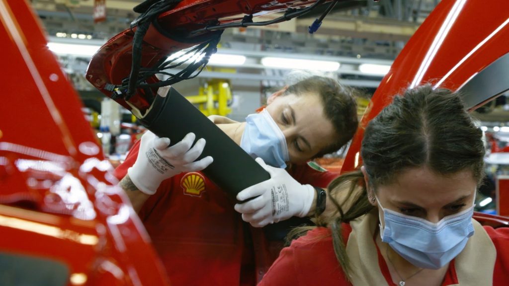 ferrari - deux femmes avec des masques ajustant les pièces de la ferrari