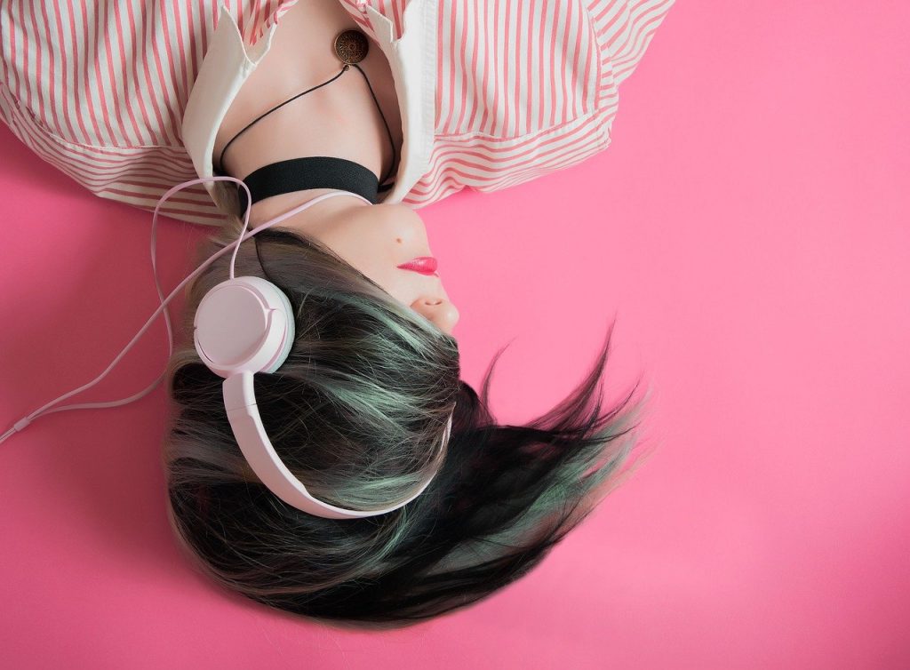 una ragazza ascolta in cuffia la sua playlist di canzoni d'amore italiane