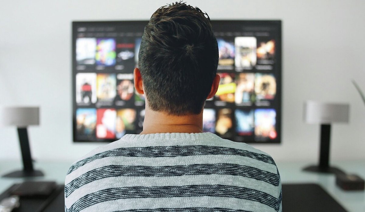 Film da guardare durante il coprifuoco - Uomo che guarda catalogo Netflix in TV