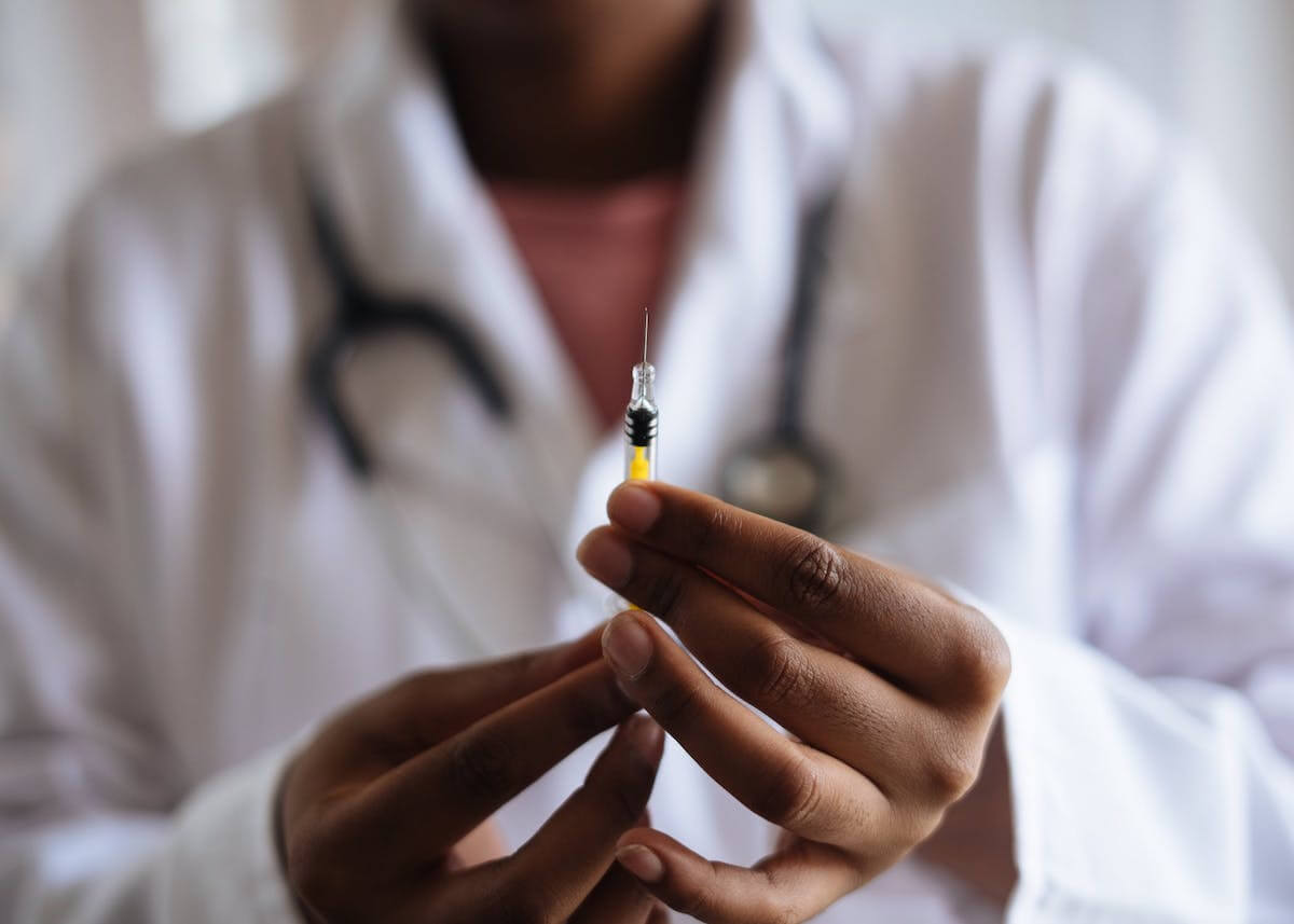 vaccini antiCovid in farmacia - medico tiene in mano siringa con vaccino