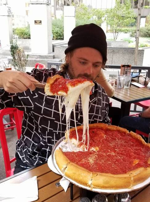 Piero Armenti intento a mangiare una pizza in stile americano. 