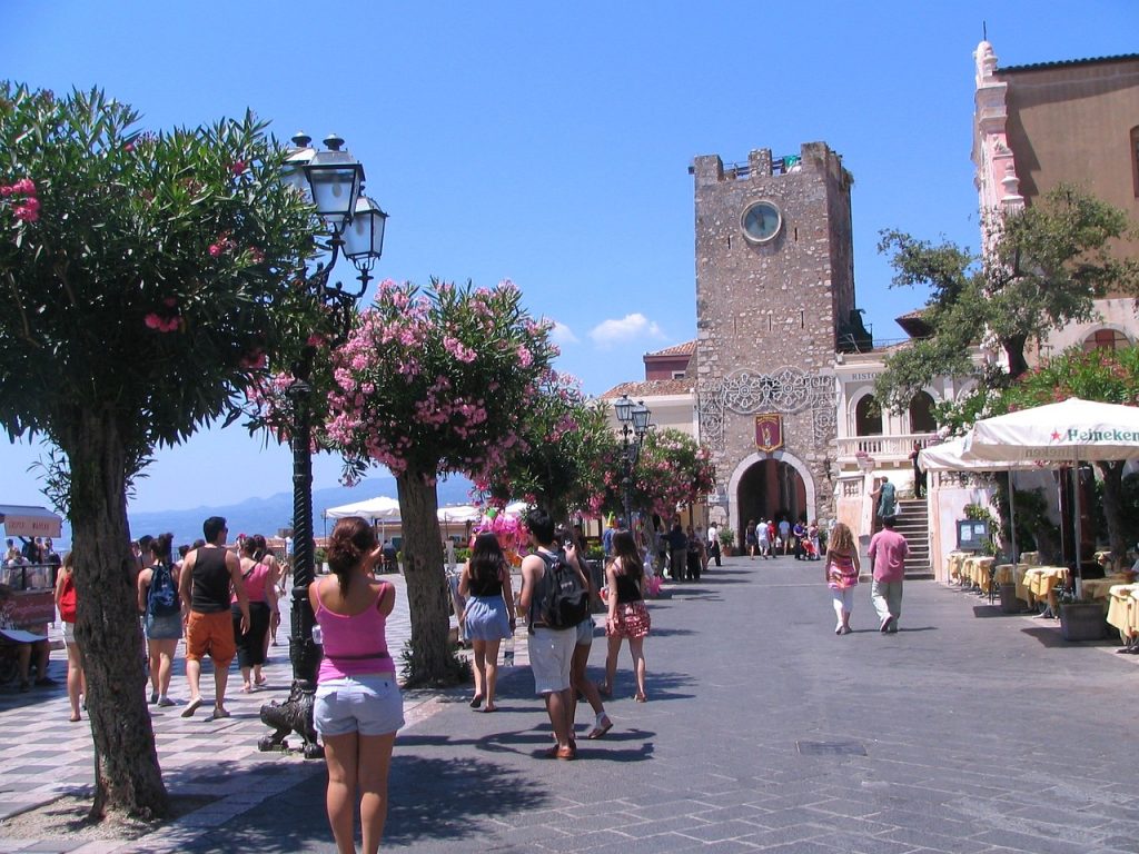 La famosa piazza con la porta e l'orologio della città, simboli di Taormina