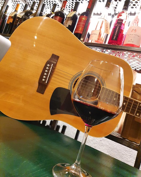 Primo piano di una chitarra e un bicchiere di vino