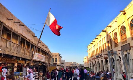 cosa visitare a Doha - souq di Doha con bandiera, negozi e gente in strada